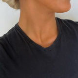 Woman wearing gold shell-shaped earrings against a white background