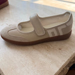 Beige shoe with a strap on a textured surface