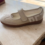 Beige shoe with a strap on a textured surface